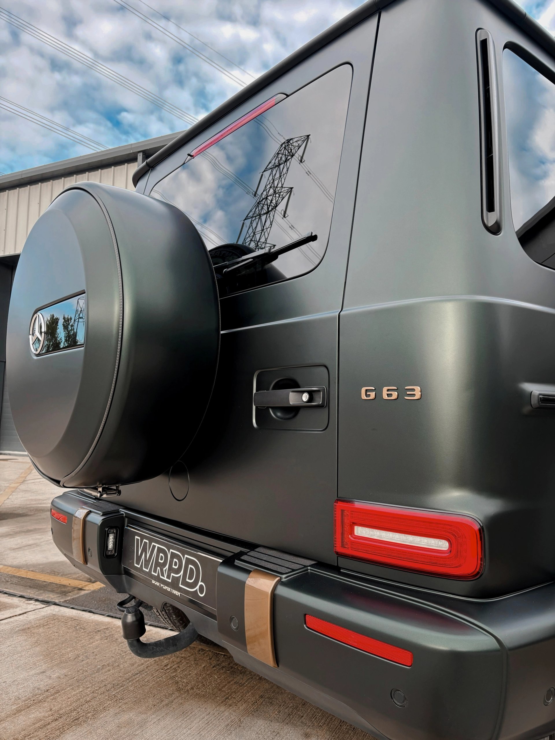 A custom Forge Mercedes G63 parked outside on concrete under a cloudy sky.