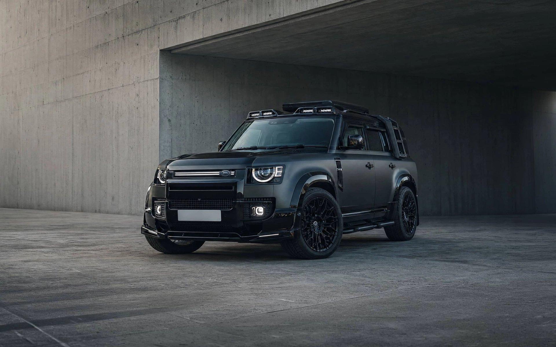 A Forge modified Land Rover Defender 130 outside a stone garage