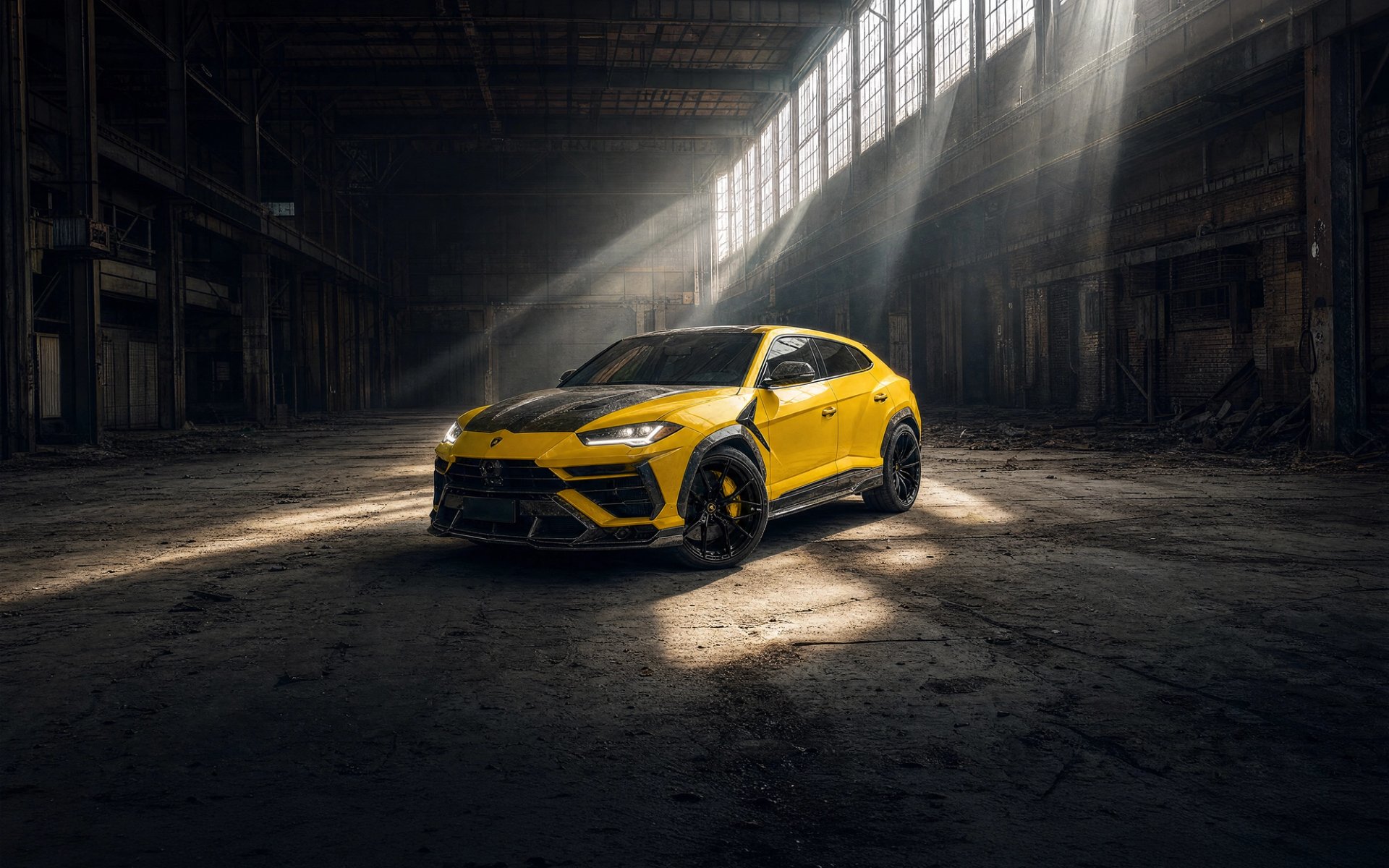 A yellow custom Forge Lamborghini Urus parked inside a rustic, sunlit warehouse.