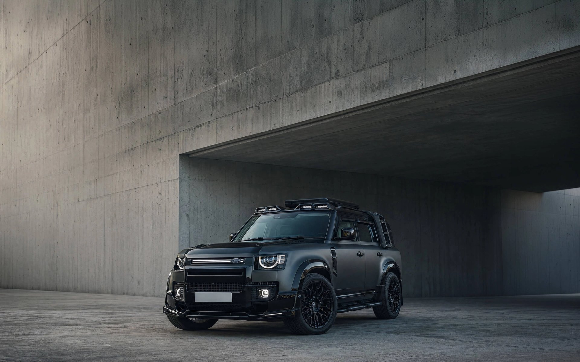 A Forge modified Land Rover Defender 130 outside a stone garage